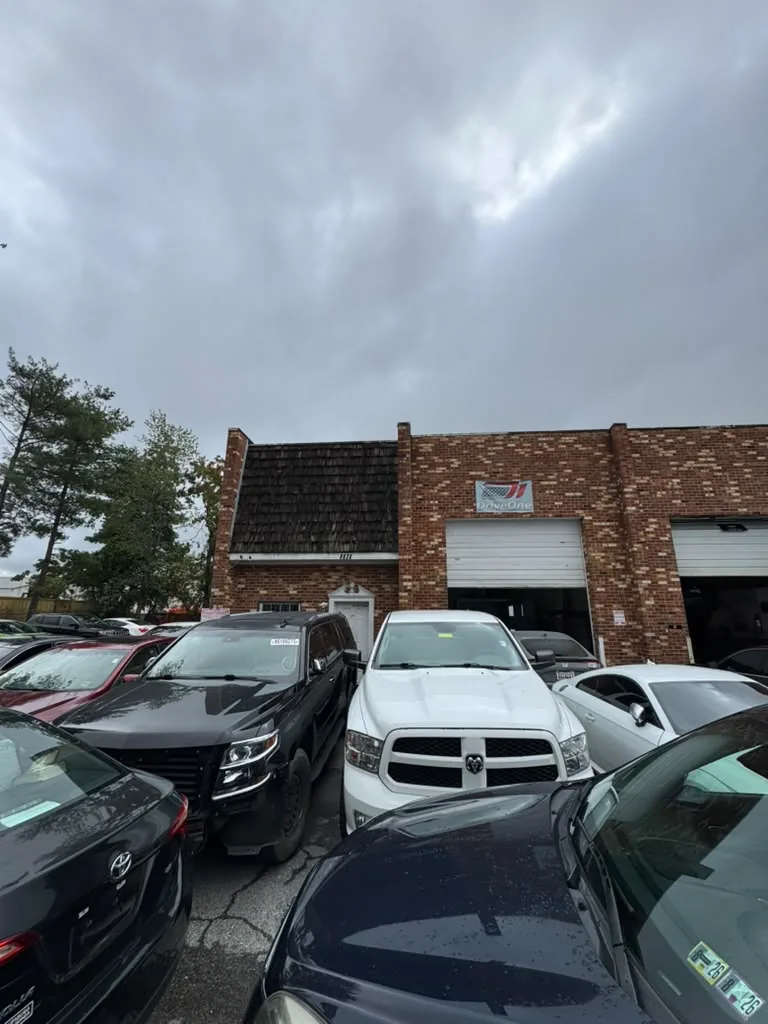 Brick auto repair building with a Drive One sign above the service bay